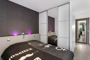 a bedroom with a bed and a large mirror at Village Naturiste - Le Caresse Port Nature Luxe in Cap d'Agde