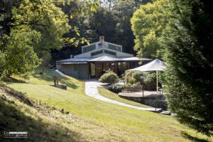 un bâtiment avec un parasol au milieu d'un parc dans l'établissement Loxley On Bellbird Hill, à Kurrajong