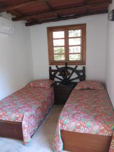 um quarto com 2 camas e uma janela em Bed & Breakfast T.T em Río Hato