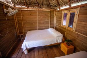 Cabañas El Arca في تييرا بومبا: غرفة نوم بسرير في كابينة خشبية