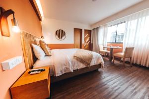 Habitación de hotel con cama y mesa en Selina Posada Miraflores en Lima