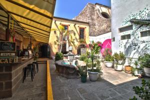 a restaurant with a bar with potted plants at Hotel Punto 79 in San Miguel de Allende