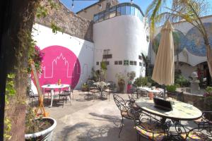 a patio with tables and chairs and an umbrella at Hotel Punto 79 in San Miguel de Allende