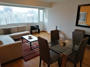 a living room with a glass table and a couch at Apart Peru in Lima