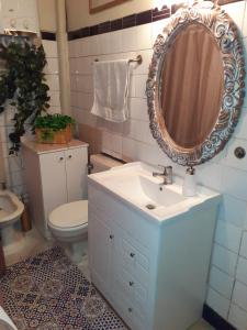 a bathroom with a sink and a mirror and a toilet at Casa dos Leones in Santiago