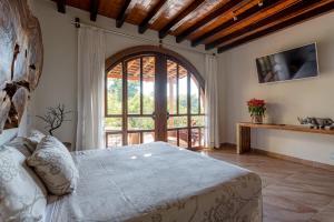 a bedroom with a bed and a large window at Suites La Hacienda in Puerto Escondido