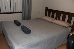 a bed with two pillows on top of it at Parkline Apartments Perth in Perth