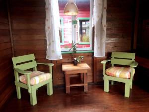 two chairs and a table in a room with a window at Hostal Hansi in Bocas Town