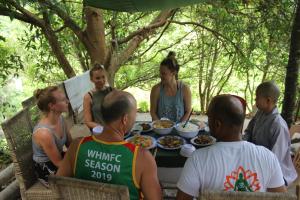 a group of people sitting around a table with food at Cham Island Smiles Homestay in Tân Hiệp
