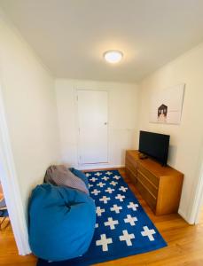 a room with a blue bean bag chair and a television at Kanasta Caravan Park in Rye