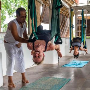 a man is doing yoga on a swing at Serenity Eco Guesthouse - CHSE certified in Canggu