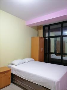 1 dormitorio con cama blanca y ventana en Hotel Sauce, en Chiclayo