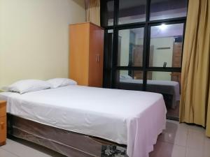 1 dormitorio con cama blanca y ventana en Hotel Sauce, en Chiclayo