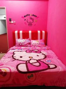 - une chambre avec un lit bonjour kitty aux murs roses dans l'établissement WORLD KIDS FANTASY, à Lumut