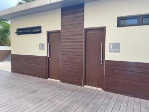 two brown doors on the side of a building at Khentdrick's Place at Holland Park Southwoods in Biñan