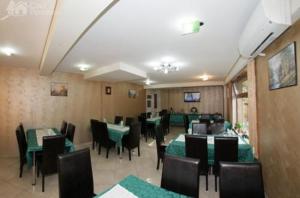 a dining room with green tables and black chairs at Pensiunea Ivu si Raul in Giroc