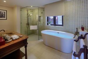 會安的住宿－Little Residence- A Boutique Hotel & Spa，大型浴室设有浴缸和淋浴。