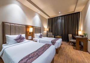 Un pat sau paturi într-o cameră la Hotel Cachar Club