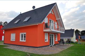 MarienfeldeにあるFerienhaus Müritzbrise / OG-Appartementの黒屋根の大きなオレンジ色の家 +3枚の写真