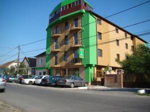 a green building on the side of a street at Pensiunea Ivu si Raul in Giroc