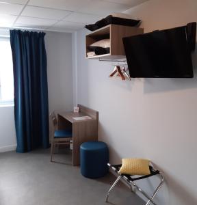 een kamer met een bureau en een tv aan de muur bij Clair de Lie in Vallet