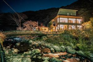 a house on a bridge over a river at 自家源泉かけ流しの温泉宿 櫻井邸 in Shimo-sagano