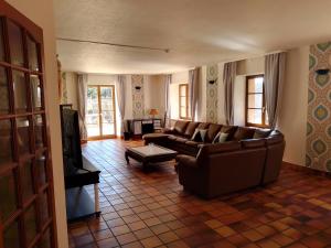 a living room with a couch and a tv at La Belle Charbonnière in La Grande Fosse