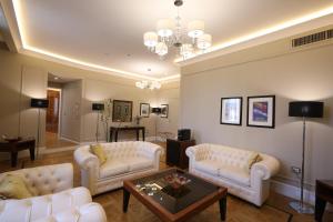a living room with white furniture and a chandelier at Grand Hotel Yerevan - Small Luxury Hotels of the World in Yerevan