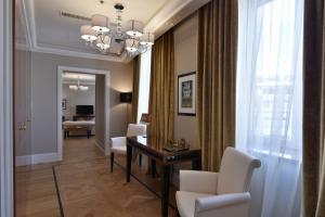 comedor con mesa, sillas y lámpara de araña en Grand Hotel Yerevan - Small Luxury Hotels of the World, en Ereván