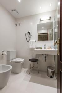 
a bathroom with a toilet, sink, and bathtub at Hotel Carlton in Bilbao
