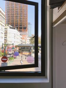 una ventana con vistas a una ciudad con sombrillas en PlainStay Hostel en Taipéi