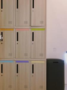 a wall of lockers in a room with a refrigerator at PlainStay Hostel in Taipei