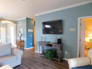 een woonkamer met een bank en een tv aan de muur bij Havens #423 condo in Myrtle Beach