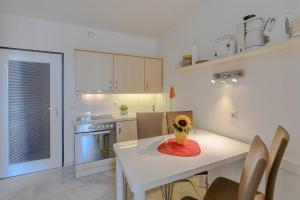a kitchen with a white table with a vase on it at Berolina Wohnung 612 in Dahme