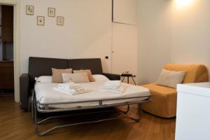 a bed in a room with a couch and a chair at Martesana Studio Flat close to Yellow Metro in Milan