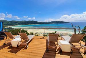 a deck with chairs and a view of the beach at VILLA KIKI Seychelles in Anse a La Mouche