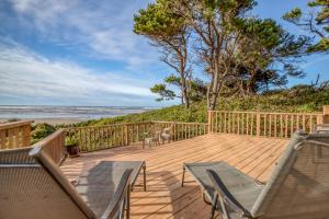 - une terrasse en bois avec des chaises et des tables sur la plage dans l'établissement Ford House, à Waldport