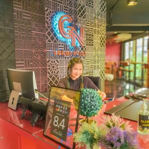 a woman sitting at a counter in a restaurant at GN Luxury Hostel in Bangkok