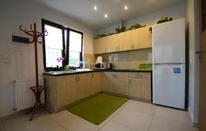 a kitchen with a white refrigerator and a green rug at Komfortowe domki letniskowe nad jeziorem na Mazurach 2 in Kruklanki +13 photos
