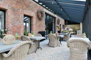 un patio avec des tables et des chaises et un bâtiment en briques dans l'établissement B&B O Chocolat Cho, à Sint-Pieters-Leeuw