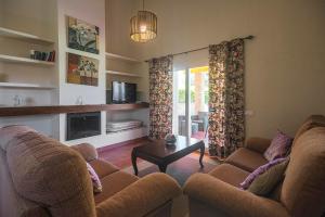 a living room with two couches and a table at Villas La Barrosa in Chiclana de la Frontera