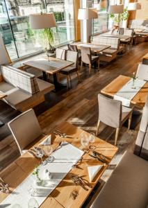 jadalnia z drewnianymi stołami i krzesłami w obiekcie Aktivhotel Pehab w mieście Ramsau am Dachstein +37 zdjęć