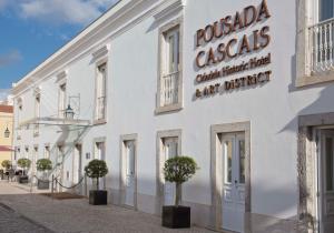 um edifício branco com árvores em frente em Pestana Cidadela Cascais - Pousada & Art District em Cascais