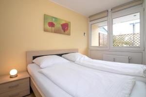 sypialnia z 2 białymi łóżkami i oknem w obiekcie Am Kampland 7 Tom w mieście Dahme