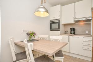 eine Küche und ein Esszimmer mit einem Holztisch und Stühlen in der Unterkunft Berolina Wohnung 301 in Dahme
