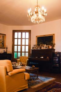 uma sala de estar com um sofá, uma mesa e um lustre em B&B Villa Sorriso em Licata