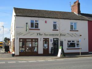 a white building on the corner of a street at The Sycamore Tree in Longtown