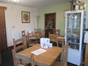 een eetkamer met een houten tafel en stoelen bij The Sycamore Tree in Longtown