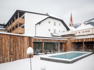 une maison avec une piscine dans la neige dans l'établissement Hotel Gasthof Jochele, à Falzes