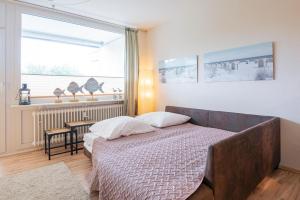 a bedroom with a bed and a window at Driftberg 1 Haus A Wohnung 24 in Grömitz